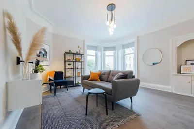 a living room with a couch and a table at Stylish Stirling Apartment - free parking in Stirling