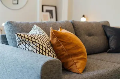 a couch with pillows on it in a living room at Stylish Stirling Apartment - free parking in Stirling