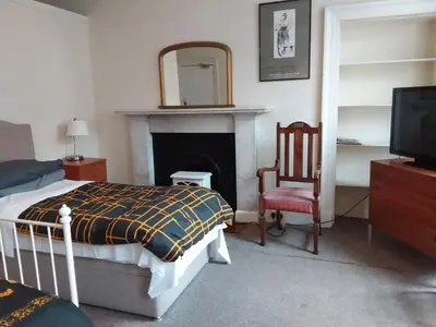a bedroom with a bed and a mirror and a fireplace at The Braveheart House in Edinburgh