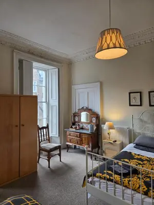 a bedroom with a bed and a desk and a chair at The Braveheart House in Edinburgh