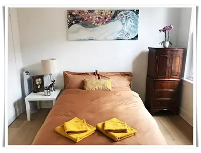 a bedroom with a bed with two yellow towels on it at Spacious and modern 2 bedroom flat near the City Centre in Edinburgh