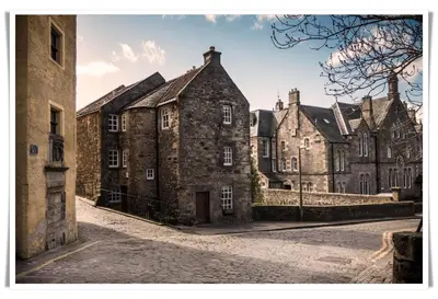 a row of old stone buildings on a cobblestone street at Spacious and modern 2 bedroom flat near the City Centre in Edinburgh