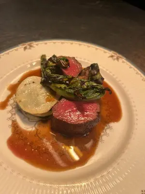 a plate of food with meat and vegetables on a table at Callander Meadows in Callander