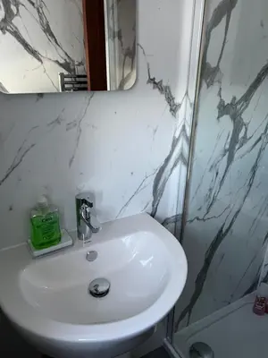 a bathroom with a white sink and a mirror at 4 bed bungalow near Airport in Edinburgh