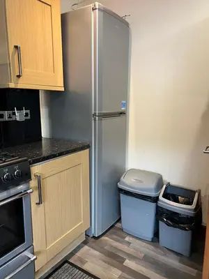 a kitchen with a refrigerator and a trash can at 4 bed bungalow near Airport in Edinburgh
