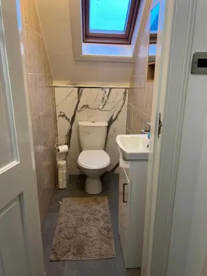 a small bathroom with a toilet and a sink at 4 bed bungalow near Airport in Edinburgh