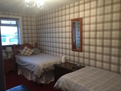 a bedroom with two beds and a mirror at Rooms at Tarrareoch in Bathgate