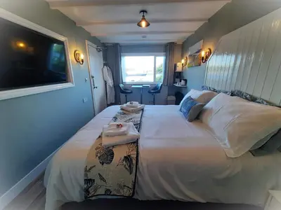 a bedroom with a large bed with a tv on the wall at Highlander House Boutique Hotel in Rothesay