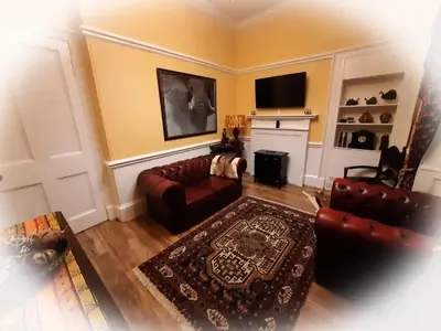 a living room with a couch and a fireplace at Highlander House Boutique Hotel in Rothesay