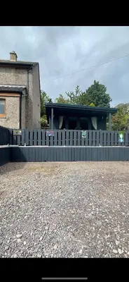 a fence in front of a house at Little bay cabin in Oban