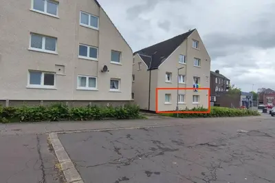 a building with an orange stripe on the side of it at Lovely 2 Bedroom Modern Ground Floor Flat in Clydebank