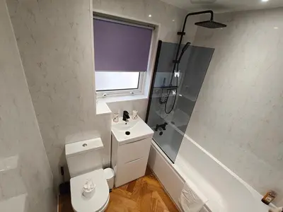 a bathroom with a toilet and a sink and a shower at Lovely 2 Bedroom Modern Ground Floor Flat in Clydebank