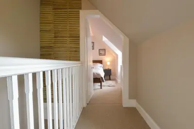 a hallway with a staircase leading to a bedroom at Achanlochan Farm in Taynuilt