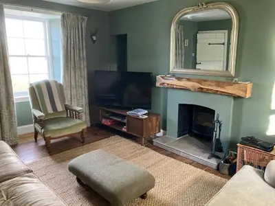 a living room with a fireplace and a mirror at Achanlochan Farm in Taynuilt