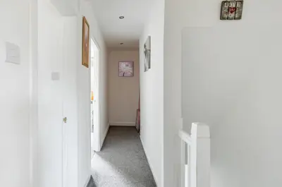 a hallway with white walls and a hallway with two doors at Captivating 3 bedroom home with conservatory in Hamilton