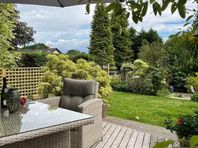 a patio with a table and a chair on a deck at The Bield in Aberfoyle