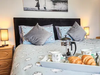 a bed with a tray of bread and croissants on it at Seven Seasons in Caldercruix