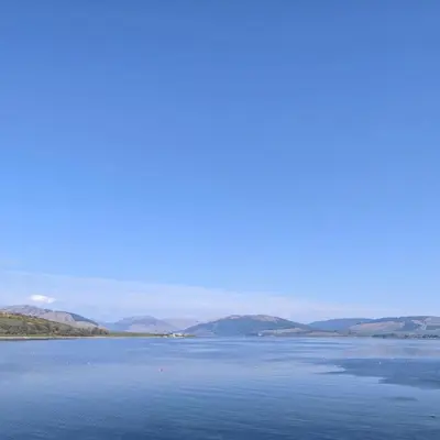 a large body of water with mountains in the background at Beautiful Upper Apartment/Stunning Sea Views, Isle of Bute in Port Bannatyne