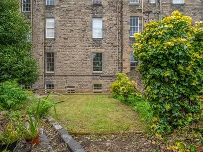 an old brick building with a garden in front of it at Superb 3Beds House in Chic area of the City Centre - Pass the Keys in Edinburgh