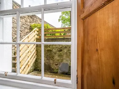 an open window with a view of a stone wall at Superb 3Beds House in Chic area of the City Centre - Pass the Keys in Edinburgh