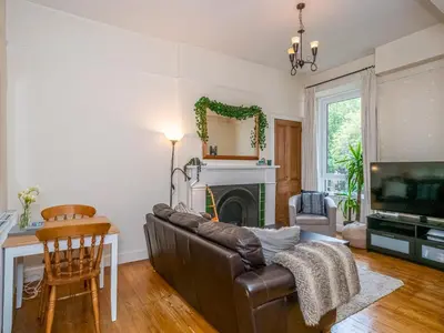 a living room with a couch and a fireplace at Superb 1 Bed Flat in Traditional Victorian Building - Pass the Keys in Edinburgh