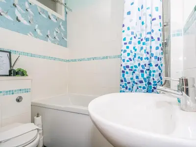 a bathroom with a sink and a toilet and a shower curtain at Superb 1 Bed Flat in Traditional Victorian Building - Pass the Keys in Edinburgh