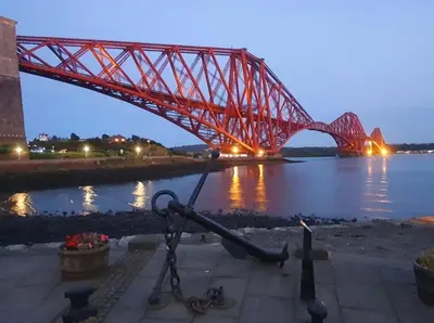 a large red bridge over a body of water at Three Bridges Waterfront in North Queensferry