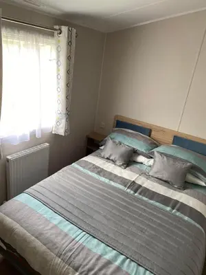 a bedroom with a bed with blue and gray stripes at Malton 74 in Dunoon