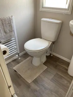 a bathroom with a white toilet and a window at Malton 74 in Dunoon