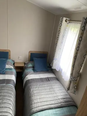 two beds sitting in a room with a window at Malton 74 in Dunoon