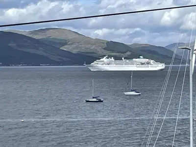 a large cruise ship in the water with boats at Beautiful 3-Bed Apartment in Gourock in Gourock