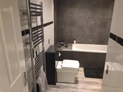 a bathroom with a toilet and a sink and a tub at Beautiful 3-Bed Apartment in Gourock in Gourock