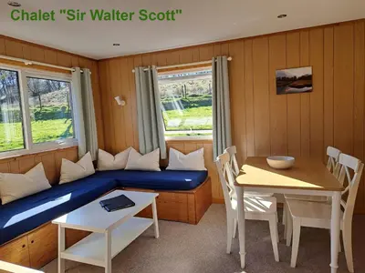 a room with a couch and a table and a window at Airdeny Chalets in Taynuilt