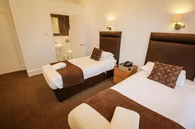a hotel room with two beds and a bathroom at Sandyford Lodge in Glasgow