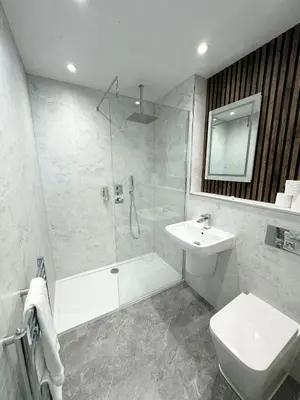 a bathroom with a shower and a toilet and a sink at Sandyford Lodge in Glasgow