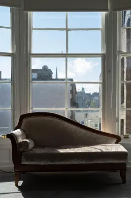 a couch in a room with a large window at Luxury Apartment/Flat Edinburgh City Centre in Edinburgh