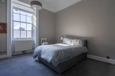 a white bedroom with a bed and a window at Luxury Apartment/Flat Edinburgh City Centre in Edinburgh