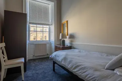 a bedroom with a bed and a chair and a window at Luxury Apartment/Flat Edinburgh City Centre in Edinburgh