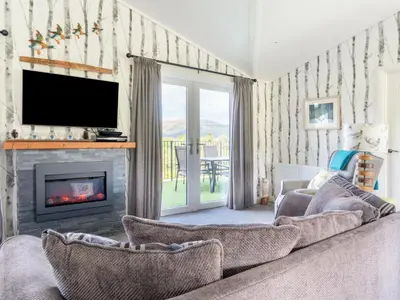 a living room with a couch and a fireplace at Chalet Loch Leven Lodge 16 Robin's Nest by Interhome in Kinross