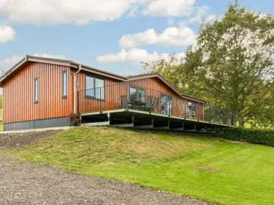 a house with a deck on top of a hill at Chalet Loch Leven Lodge 16 Robin's Nest by Interhome in Kinross