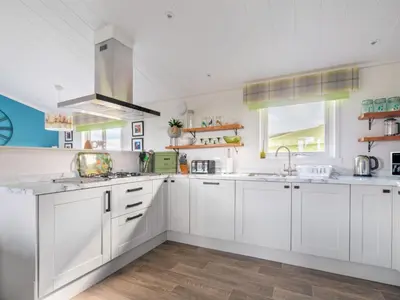 a kitchen with white cabinets and a sink at Chalet Loch Leven Lodge 16 Robin's Nest by Interhome in Kinross