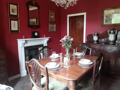 a dining room with a wooden table and a fireplace at Beautiful Traditional secluded country cottage in Sanquhar