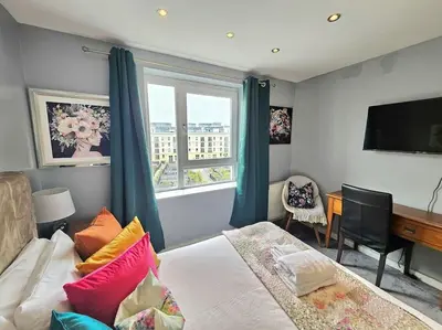a bedroom with a bed and a desk and a window at 4 Separate Beds, Sleeps 6, Beautiful 2 bed Apt in Edinburgh