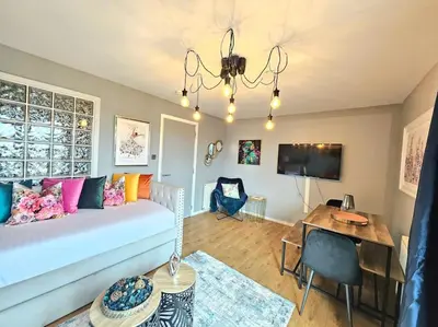 a living room with a white couch and a table at 4 Separate Beds, Sleeps 6, Beautiful 2 bed Apt in Edinburgh