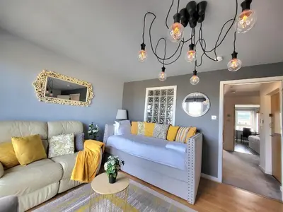 a living room with a white couch and yellow pillows at 4 Separate Beds, Sleeps 6, Beautiful 2 bed Apt in Edinburgh