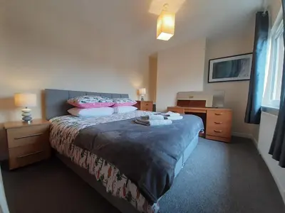 a bedroom with a bed and a desk and a television at Carvetii - Zelda House - 4 bedroom house, sleeps 8 in Oakley