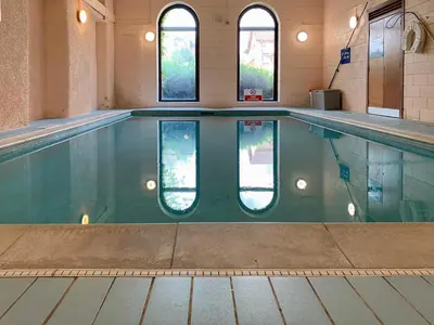 a swimming pool with three windows in a building at Mill Court in Dunblane