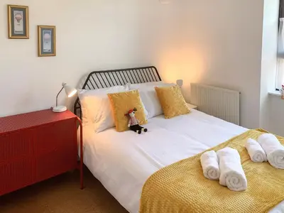 a bed with a teddy bear sitting on top of it at Mill Court in Dunblane
