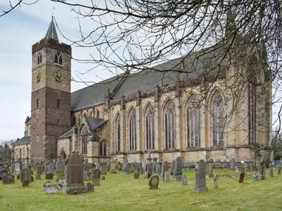 a church with a clock tower and a cemetery at Mill Court in Dunblane