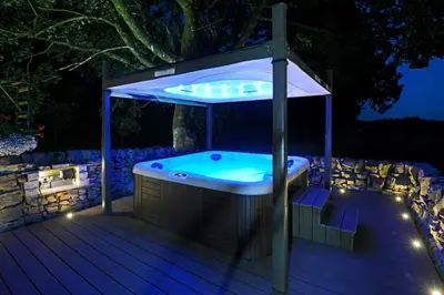 a hot tub in a gazebo at night at Craigadam Lodge with Hot tub in Castle Douglas